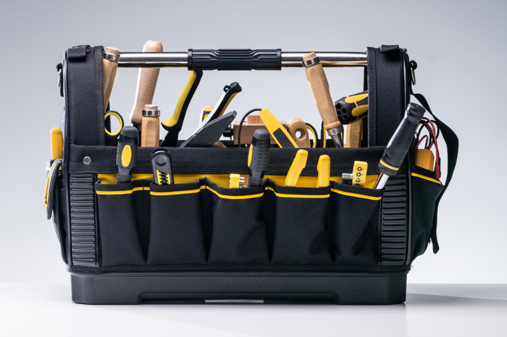 Tool bag with screwdrivers, pliers, and hammers organized in yellow and black pockets